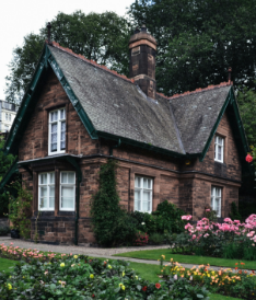 A brick house with pink flowers in front of it.